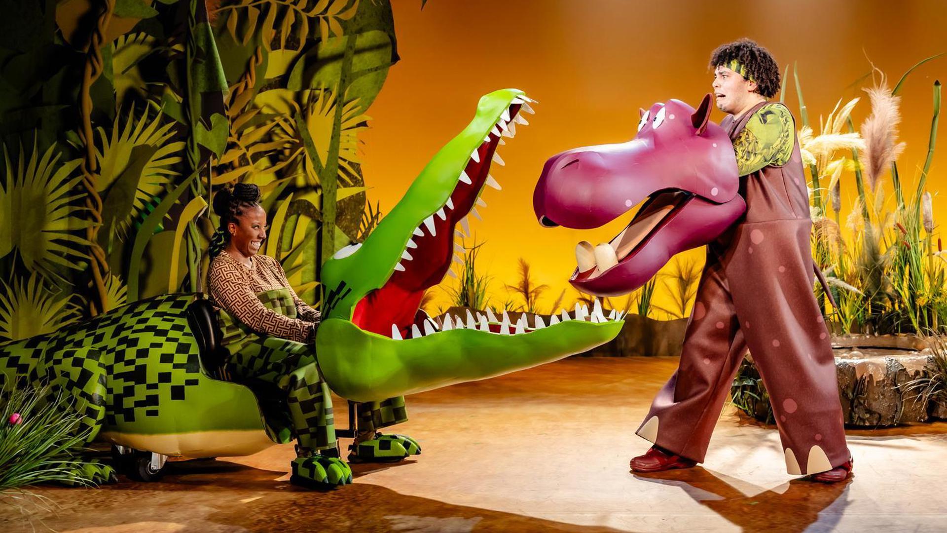 The Enormous Crocodile opens his jaws towards a scared hippo.