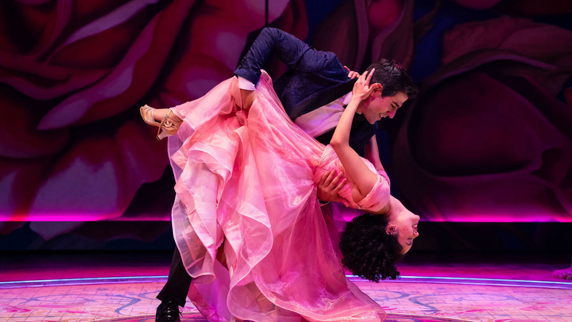 An actor dips another actor in a dance move.