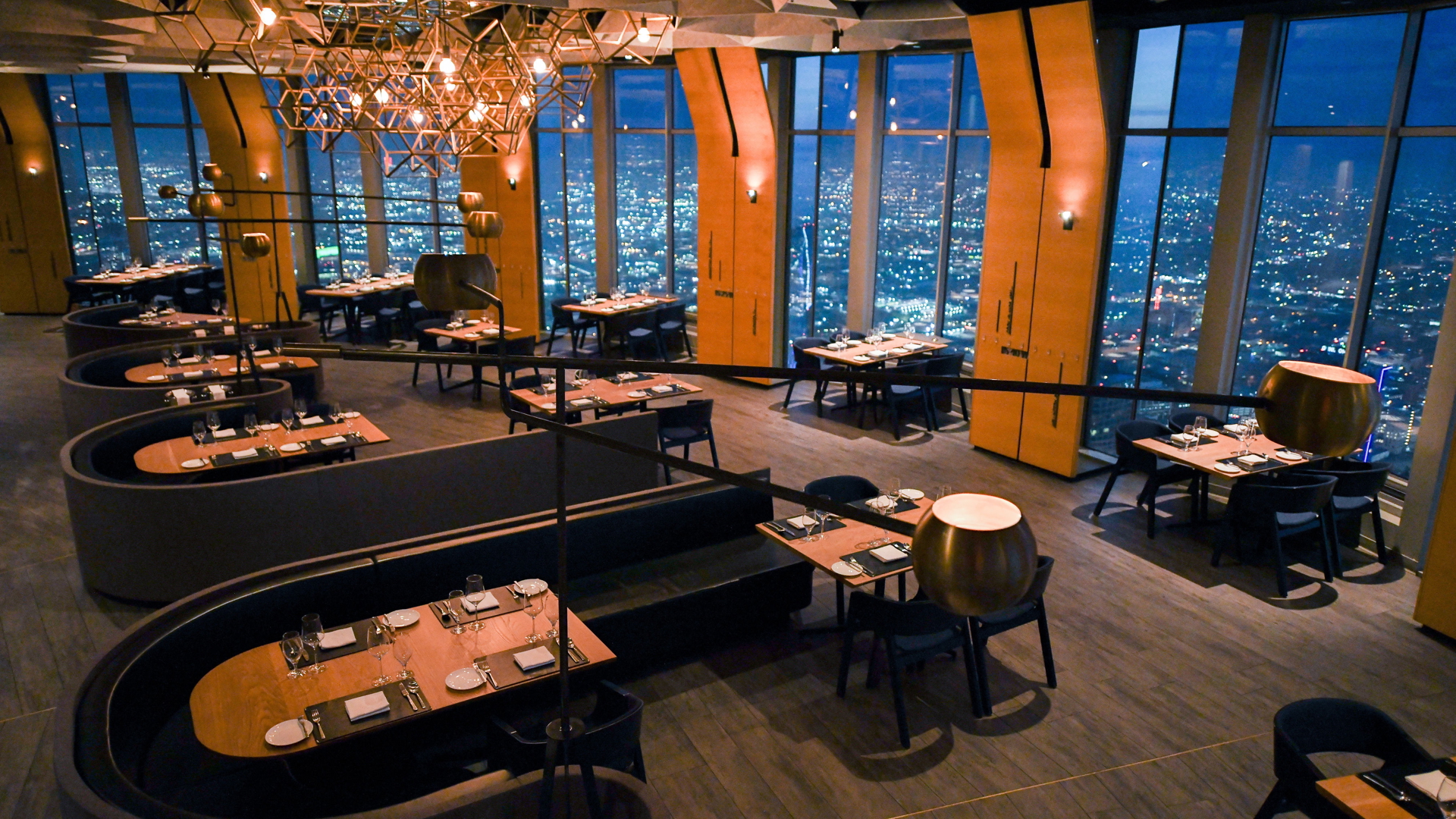 Interior photo of Above71's dining hall featuring the Los Angeles' evening cityscape in the background. 