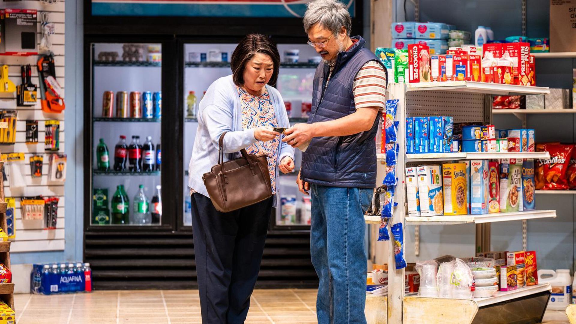 Two people hold an item looking puzzled. 